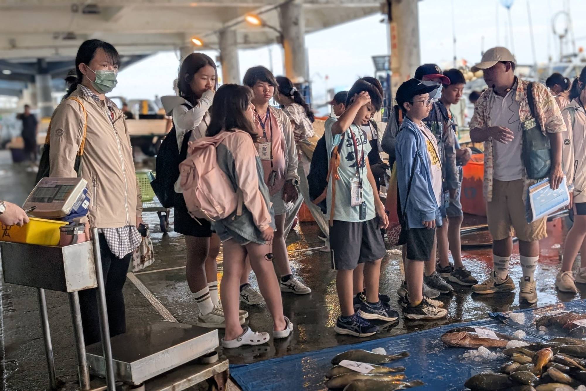 教育學系師資生與篤加國小老師安排學童早起參訪當地魚市,學習魚種辨別與競標過程