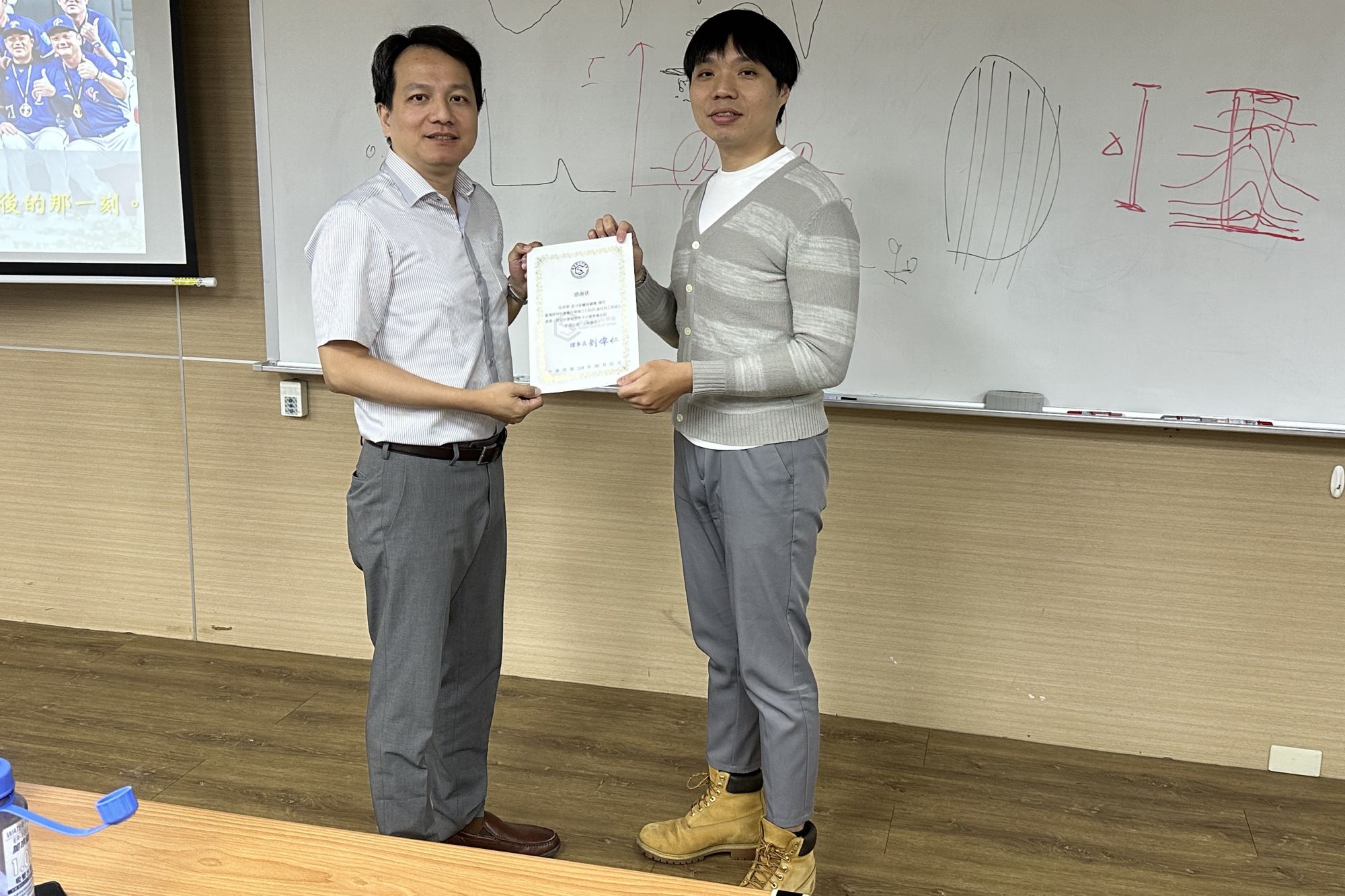 南大育成中心活動現場,碳材料學會副理事長黃啓賢教授頒發感謝狀予新國科技許立昇副理,肯定產學合作的重要貢獻。