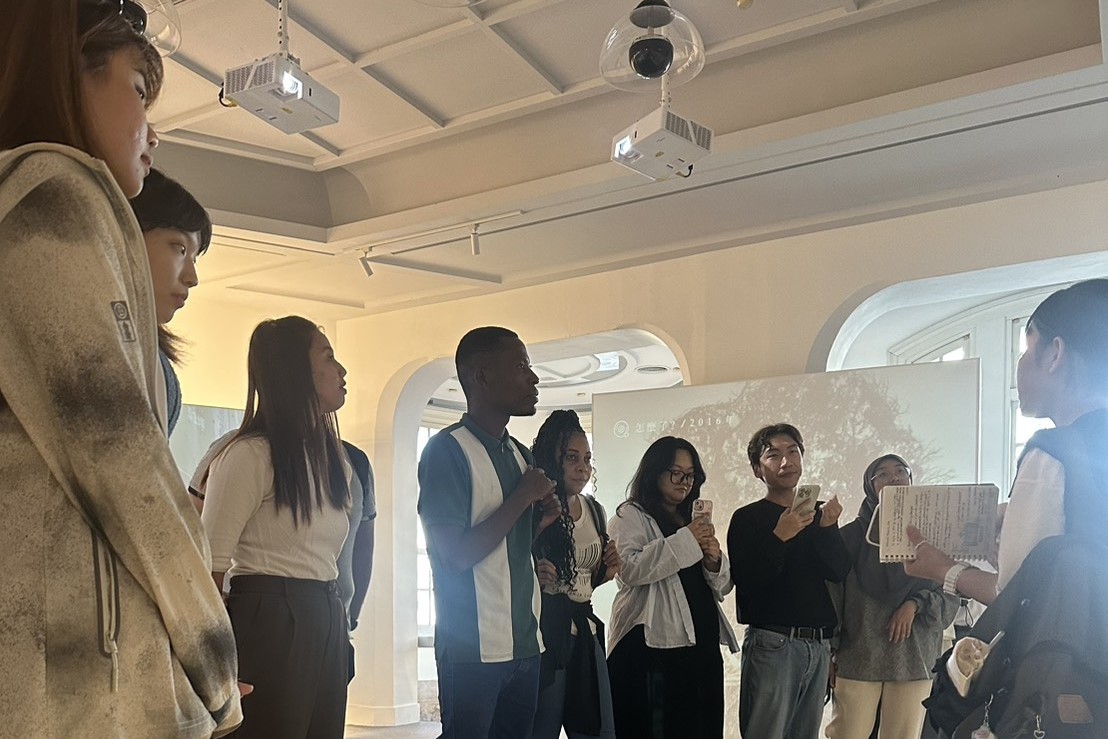 南大學生以流暢英語導覽臺灣文學館,外籍生專注傾聽,感受古都文學與文化的深厚底蘊。