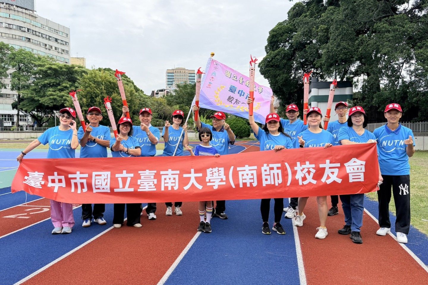 南大聖火抵達臺中,校友們身著藍T與紅帽進場,以創意與活力迎接聖火。