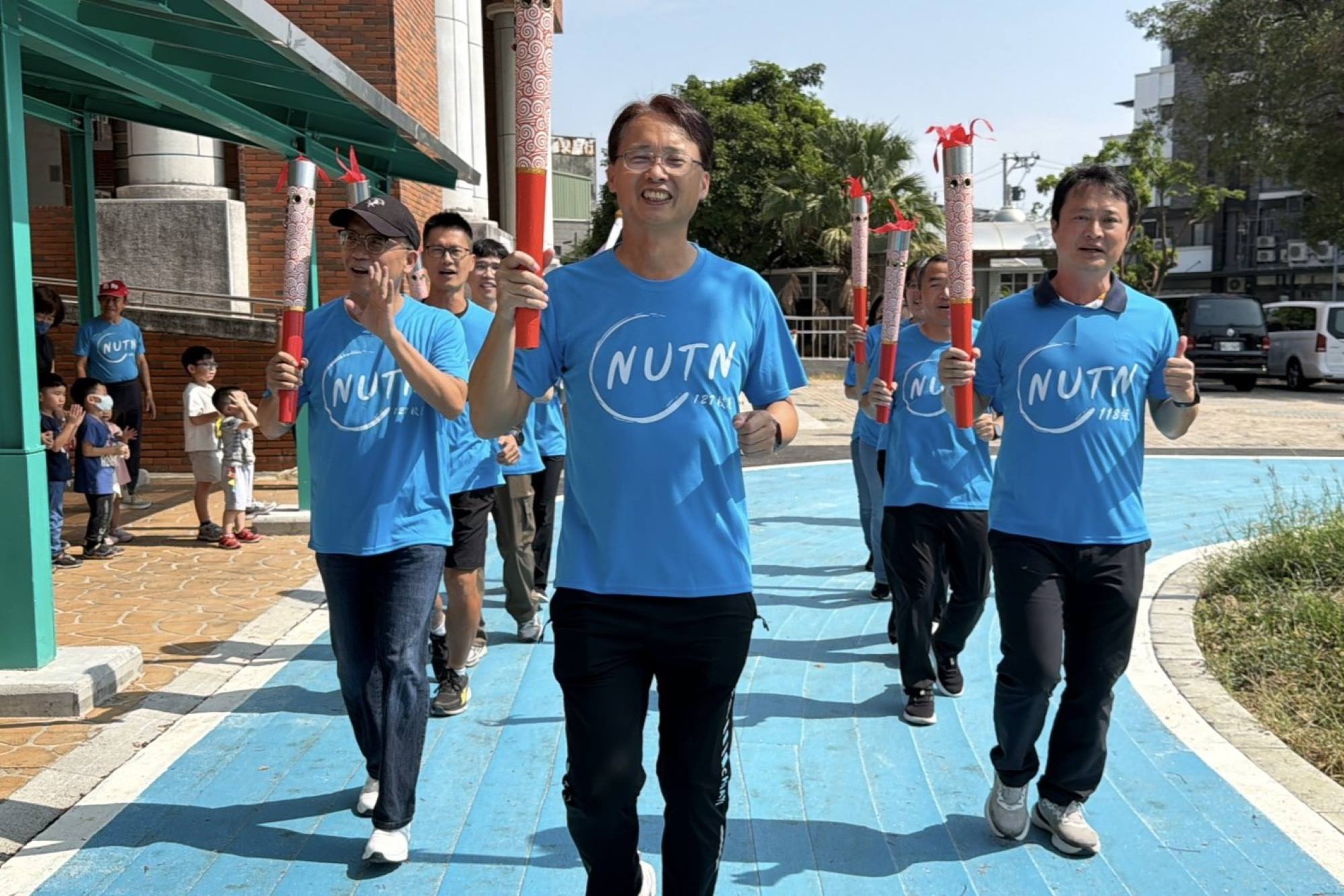 嘉義地區校友手持南大聖火奔跑進場,以行動展現傳承與團結的精神。