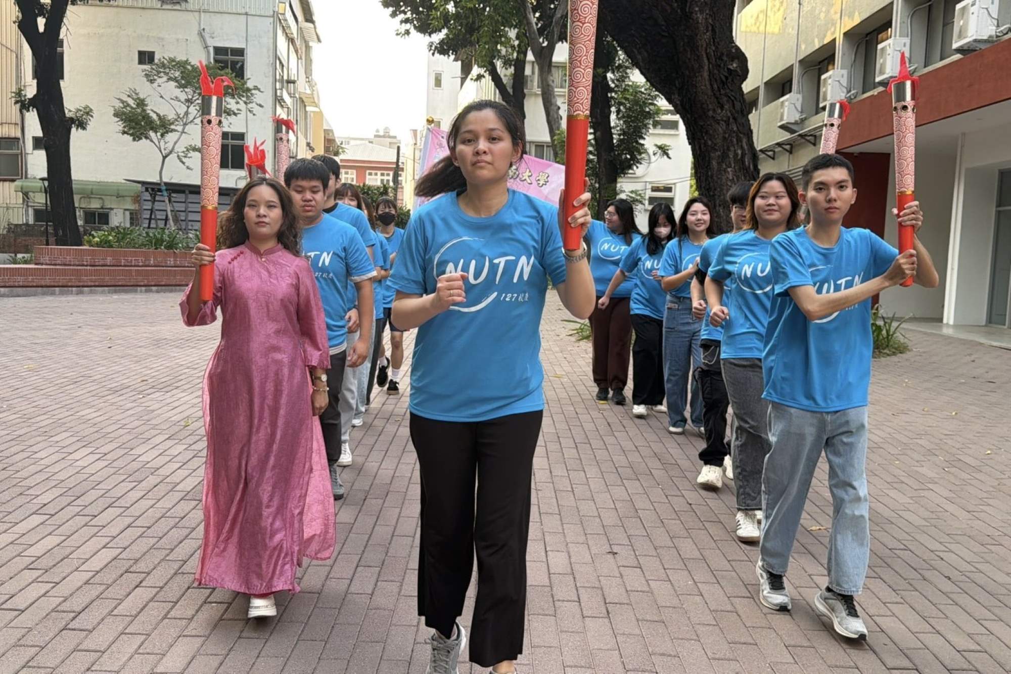 留臺新住民校友與南大學生以自信步伐傳遞聖火,象徵新世代南大人的熱情與希望。
