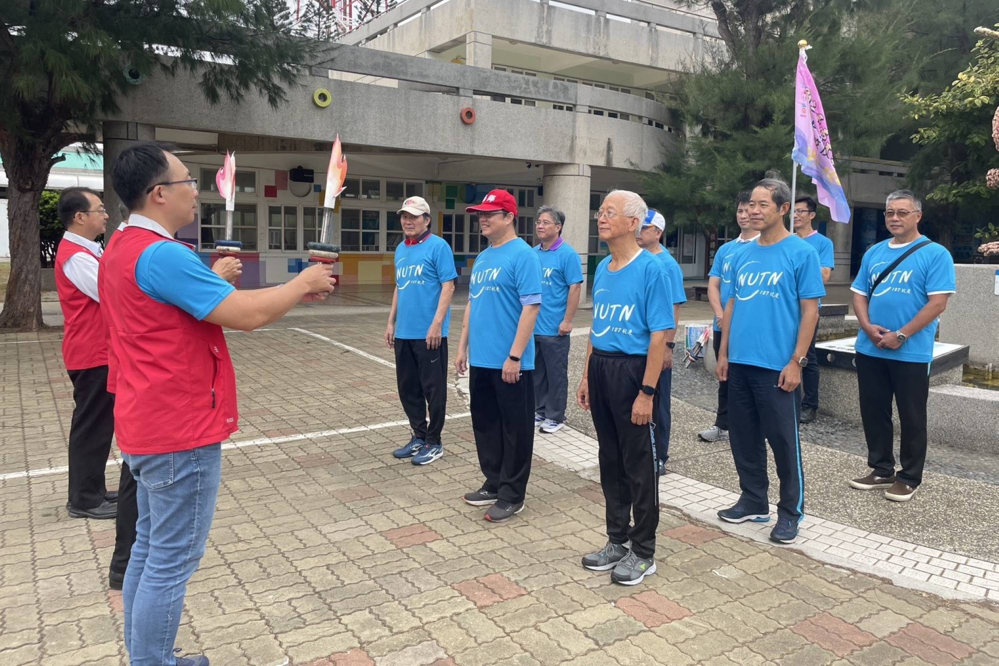 南大澎湖縣校友會成員穿著「NUTN 127校慶」紀念T恤整齊列隊,共同迎接聖火到來,展現離島校友對母校的深厚情誼。