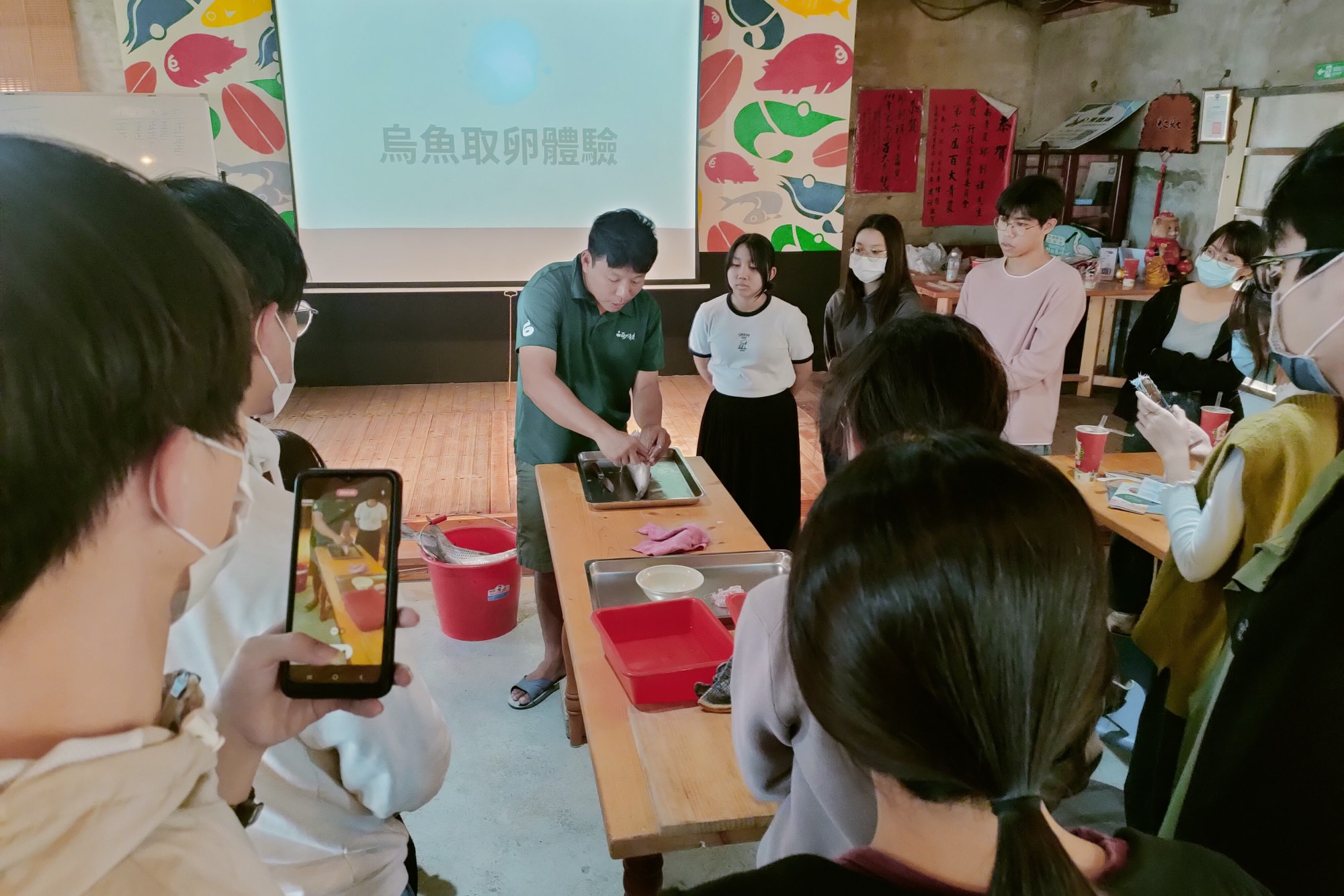 在地青農邱創褘示範烏魚取卵步驟,向南大師生解說養殖與加工的實務細節。
