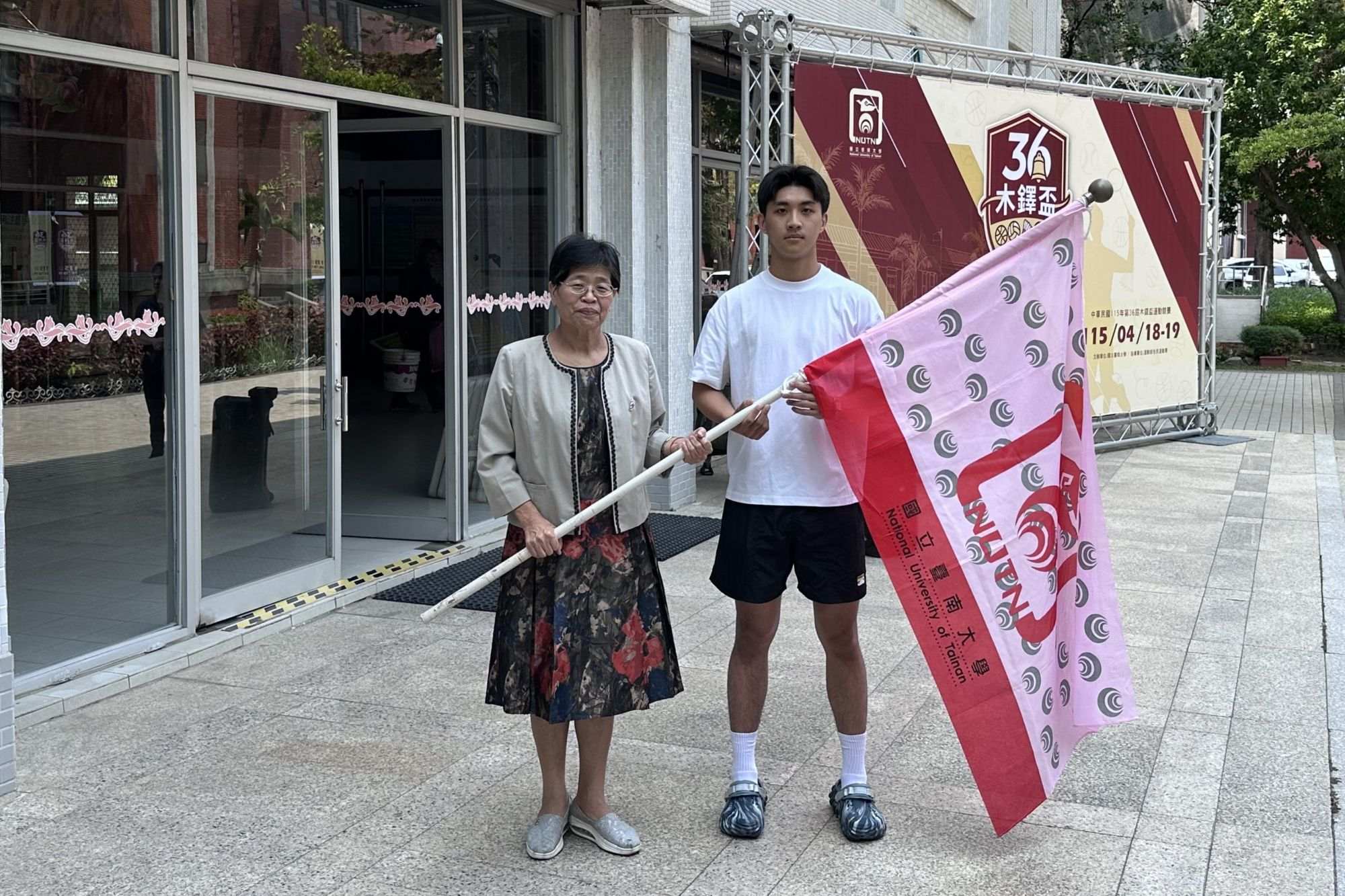 南大舉行木鐸盃授旗儀式,校長陳惠萍(左)親自授旗,凝聚代表隊士氣,展現全校一心迎接賽事的團隊氣勢。