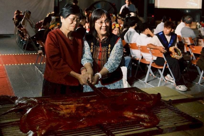 南大陳惠萍校長與南市府原民會白惠蘭主任委員,於典禮中共同分切阿里山鄒式烤全豬,以原民飲食文化揭開聯合原畢典序幕,熱情洋溢。