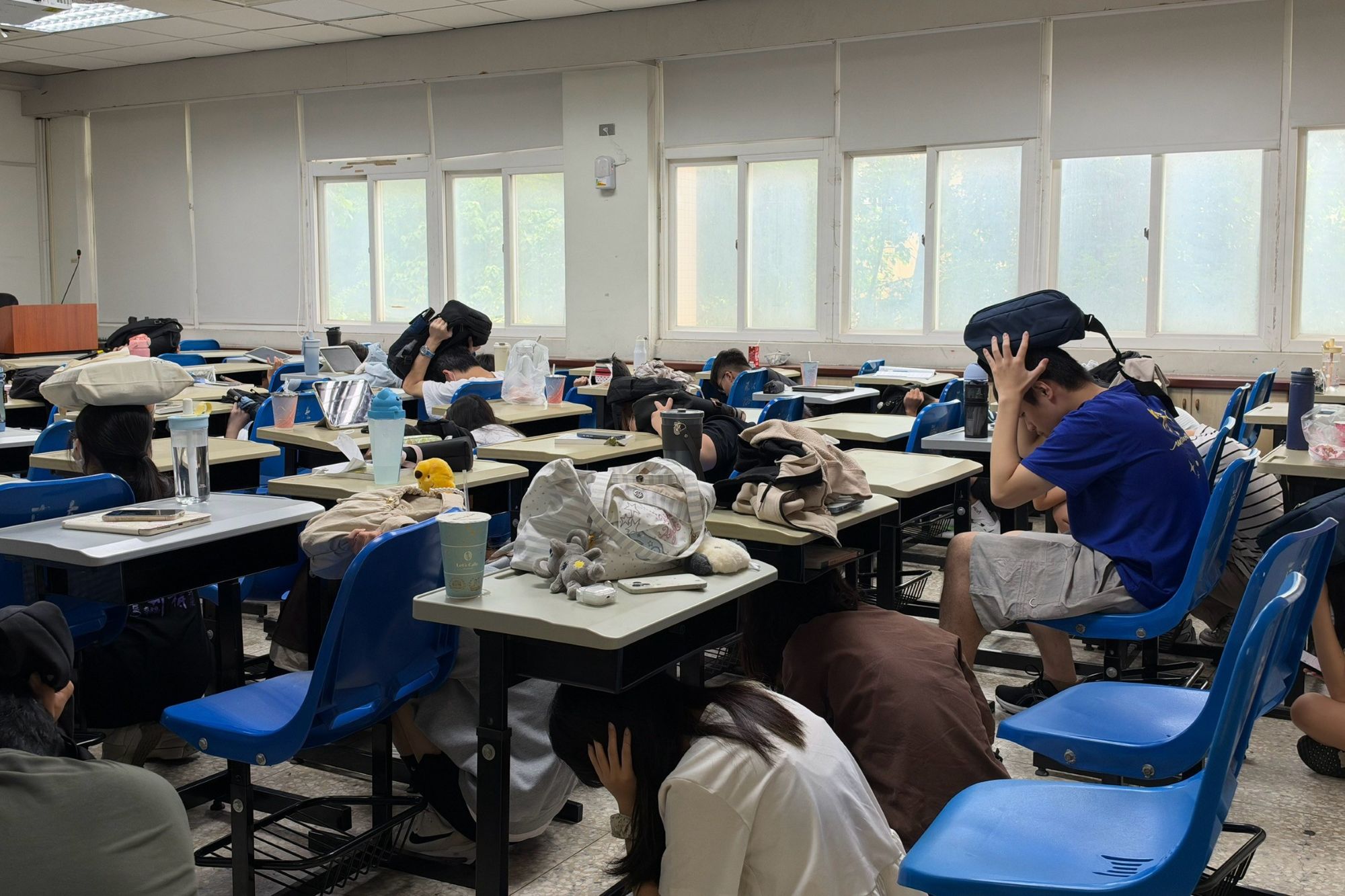地震演練警報響起,南大學生立即「趴下、掩護、穩住」,落實防災行動。