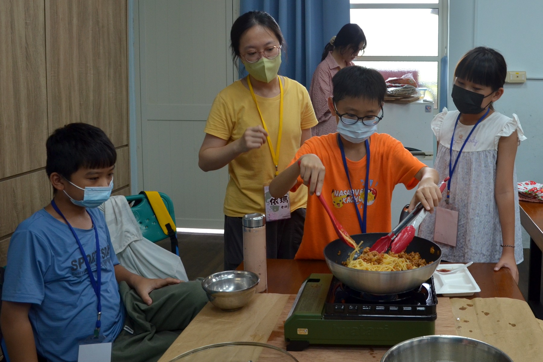 學生化身小小廚師翻炒番茄肉醬義大利麵,透過南大食農營隊體驗料理樂趣與生活實作。